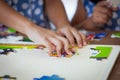 Child little girl hand trying to connect jigsaw puzzle piece Royalty Free Stock Photo