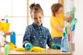 Child little girl and mother cleaning living room at home