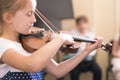 Child, little girl playing violin indoors in music class Royalty Free Stock Photo