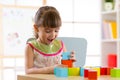 Child little girl playing wooden toys at home or kindergarten Royalty Free Stock Photo