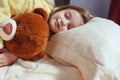 Child little girl sleeps in the bed with a toy teddy bear Royalty Free Stock Photo