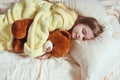 Child little girl sleeps in the bed with a toy teddy bear Royalty Free Stock Photo