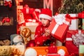 Child little happy boy find gifts near christmas tree. Gifts shop. Kid santa hat christmas gift boxes. Merry christmas