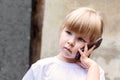 Child, little kid speaking on mobile phone alone. Young girl holding a smartphone next to her ear talking, closeup Royalty Free Stock Photo