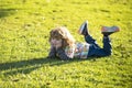 Child liyng outdoor. Kid in park. Spring Boy lie down on grass. Summer walk. Children adaptation. Royalty Free Stock Photo