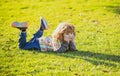 Child liyng outdoor. Kid in park. Spring Boy lie down on grass. Summer walk. Children adaptation. Royalty Free Stock Photo