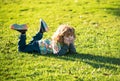 Child liyng outdoor. Kid in park. Spring Boy lie down on grass. Summer walk. Children adaptation. Royalty Free Stock Photo