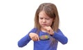 Child with long hair pulling out hair from brush