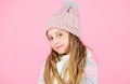 Child long hair warm soft woolen hat enjoy softness. Kid girl wear knitted soft hat pink background. Keep knitwear soft Royalty Free Stock Photo