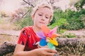 Child with a look of wonder and strangeness when discovering a pinwheel