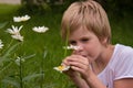 The child looked carefully at the flowers on a green meadow. Curiosity and the study of the environment. nature.