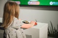 Child looking at a big television screen, playing a game Royalty Free Stock Photo