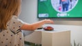 Child looking at a big television screen, playing a game Royalty Free Stock Photo