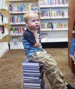 Child looking for a book on the shelf at the library Royalty Free Stock Photo