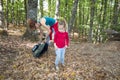 Child looking in forest in autumn near mother with backpack