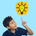 Child looking happy and pointing at light bulb. Success, idea, win and innovation technology Royalty Free Stock Photo