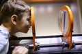 Child looking through magnifying glass system