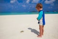 Child looking to crab at tropical beach with overwater bungalows Royalty Free Stock Photo