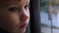 Child looking through window. Close-up shot of a kid looking out of the window in train. Close-up back side view