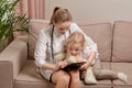 The child looks into the doctor clipboard.