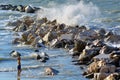 Child looks at the force of the sea waves breaking against the rocks Royalty Free Stock Photo