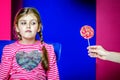 The child looks incredulously at the candy.