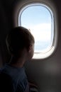 A child looks out the window of an airplane