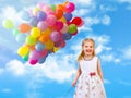 Child and a lot of balloons on a background of blue sky and clouds. Royalty Free Stock Photo