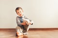 Child with lots of independence sitting on the floor putting on his socks with an expression of effort