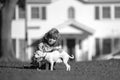 Child lovingly embraces his pet dog. Happy little kid boy playing with puppy in garden.