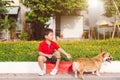 Child lovingly embraces his pet dog, a pembroke corgi