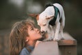 Child lovingly embraces and kisses his pet dog.