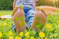 Child lying on green grass. Kid having fun outdoors in spring park. Child feet with painting smiles lying on green grass. Royalty Free Stock Photo