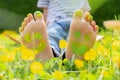 Child lying on green grass. Kid having fun outdoors in spring park. Child feet with painting smiles lying on green grass Royalty Free Stock Photo