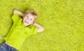 Child Lying Over Green Carpet. Happy Smiling Kid Boy Royalty Free Stock Photo