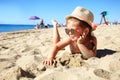 Child lying on sandy beach near blue sea. Summer vacation and healthy lifestyle concept.