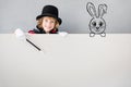 Child magician hiding behind banner blank Royalty Free Stock Photo