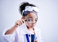 Child, magnifying glass and portrait of a scientist girl in studio with eye for scientific research. Face of a African