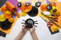 The child makes black spiders of paper. Master Class. Handmade crafts.