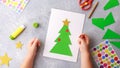 The child makes a greeting card Christmas paper collage. Children`s art project craft for kids Royalty Free Stock Photo