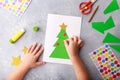 The child makes a greeting card Christmas paper collage. Children`s art project craft for kids Royalty Free Stock Photo