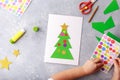 The child makes a greeting card Christmas paper collage. Children`s art project craft for kids Royalty Free Stock Photo