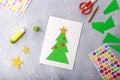 The child makes a greeting card Christmas paper collage. Children`s art project craft for kids Royalty Free Stock Photo