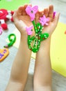 Child making bouquet, flowers from plasticine, clay, beads. little girl creating gift for mom gift for Mothers day, Birthday or