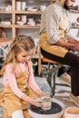 child making ceramic pot on pottery wheel with teacher Royalty Free Stock Photo