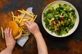 Child making choice between healthy salad and fast food Royalty Free Stock Photo