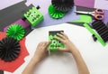 A child making decorum of Halloween from colored paper.