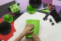 A child making a Frankenstein decorum of Halloween from colored paper.