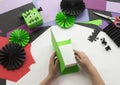 A child making a Frankenstein decorum of Halloween from colored paper.