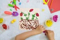 Child making harvesting of fresh red strawberry fruit from paper and plasticine, applique. Crafts for children. Children